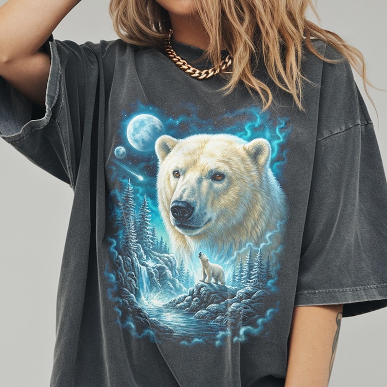 A vintage-style graphic on a black Comfort Colors shirt featuring a white Polar Bear portrait and a silhouette standing on an ice floe under a moon in a blue arctic setting.