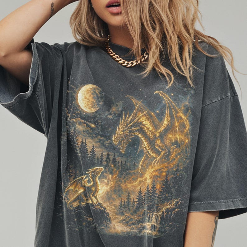 A vintage-style graphic on a black Comfort Colors shirt featuring a golden spirit Dragon and a baby dragon under a full moon in a starry forest.