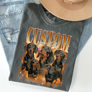 Custom bootleg rap tee featuring dachshund sausage dog photos, orange fire background, personalized pet portrait on black comfort colors shirt, 90s hip hop style.