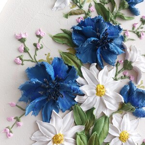Puede incluir: Un primer plano de una pintura floral 3D con flores blancas y azules. Las flores est&aacute;n pintadas con un estilo realista y parecen tener textura. El fondo es de color crema claro.