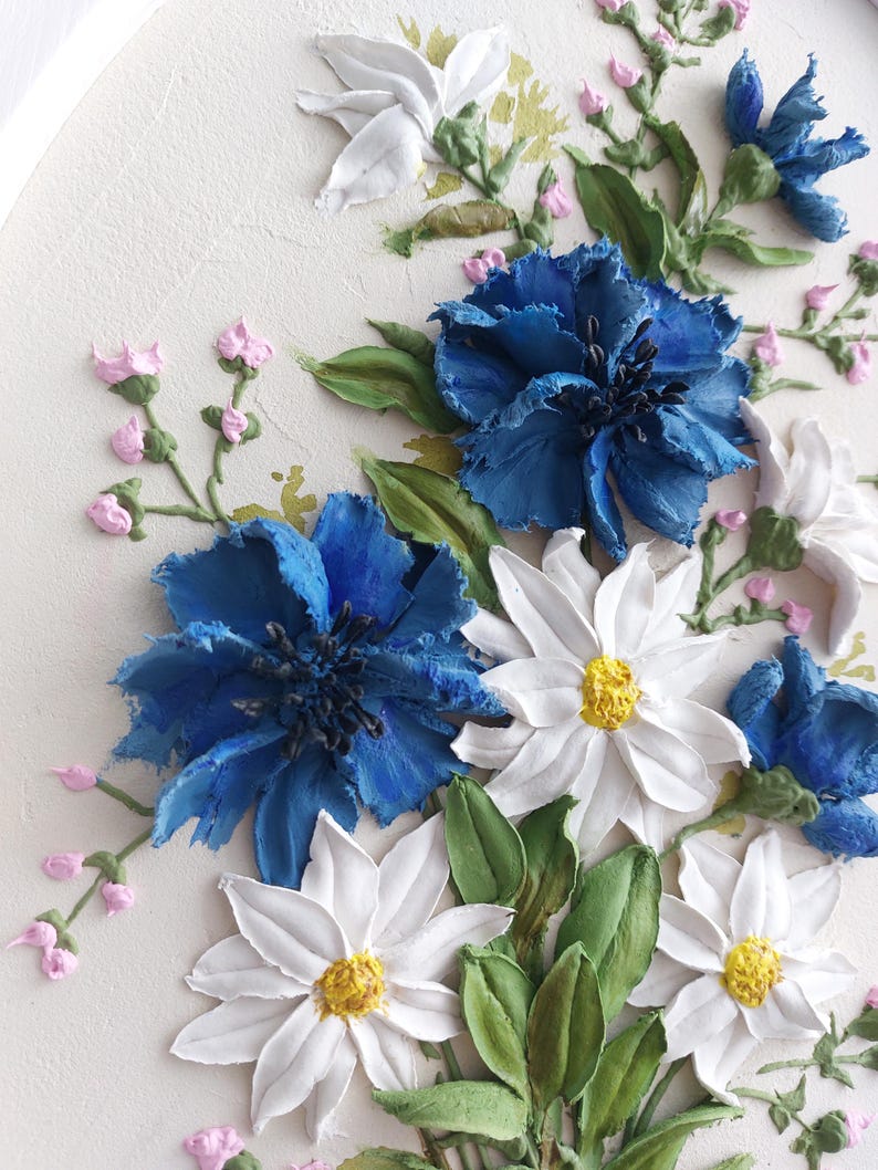 Puede incluir: Un primer plano de una pintura floral 3D con flores blancas y azules. Las flores est&aacute;n pintadas con un estilo realista y parecen tener textura. El fondo es de color crema claro.