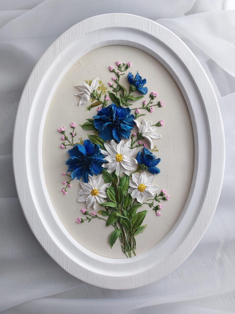 Puede incluir: Un marco ovalado blanco con un fondo blanco y un ramo de flores azules y blancas. Las flores est&aacute;n pintadas en un estilo realista y tienen un efecto 3D.