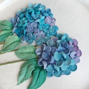 Peinture sculpturale, plâtre décoratif, hortensias bleus, art floral 3D, élégance texturée, harmonie printanière, forme unique, beauté de la toile