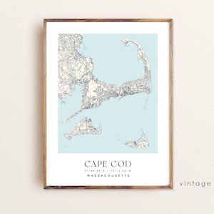 May include: A vintage style map of Cape Cod, Massachusetts. The map is printed on a light blue background and shows the roads and towns of the Cape. The text "CAPE COD" is printed in black at the bottom of the map, along with the coordinates "41°40'48"N / 70°12'00"W" and the text "MASSACHUSETTS".