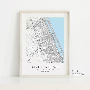 May include: Framed map print of Daytona Beach, Florida, featuring a detailed black and white city map with a light blue ocean area. The text "DAYTONA BEACH" and coordinates are displayed below the map. The style is modern.