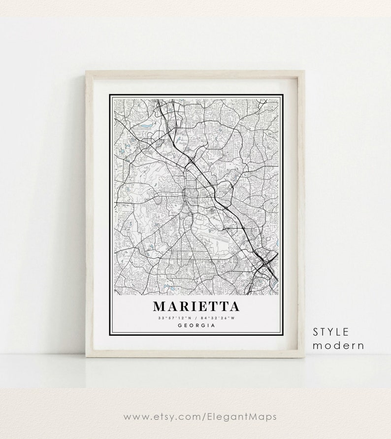 May include: Framed black and white map print of Marietta, Georgia, with street details and coordinates. The print is labeled "Marietta" and "Georgia" in a minimalist style, with the words "Style Modern" on the right side.
