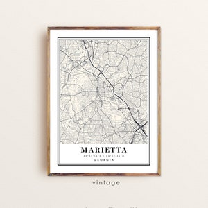 May include: A framed map print of Marietta, Georgia, in black and white. The map details the city's streets and roads. The word "Marietta" is centered at the bottom, with coordinates and "Georgia" below. The word "vintage" is printed below the city name.