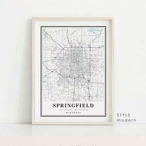 May include: A framed map print of Springfield, Missouri, in black and white. The map shows the city's layout, including roads and waterways. The city name and coordinates are printed at the bottom. The style is modern.