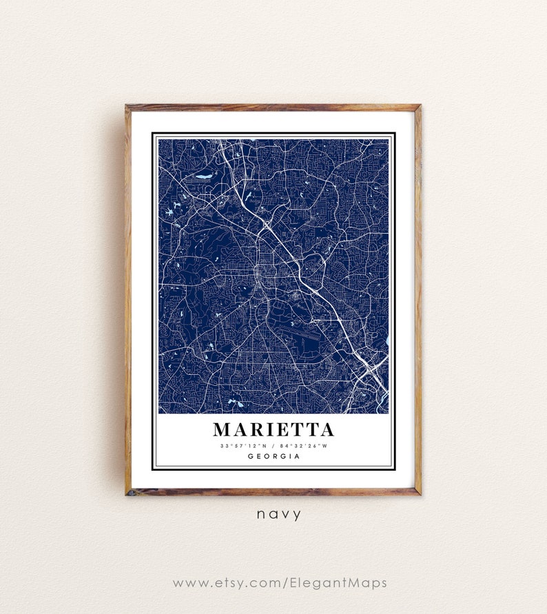 May include: Navy blue map print of Marietta, Georgia, framed in a wooden frame. The map features white street and road details. The city name and coordinates are displayed at the bottom, with the word "navy" below. The website address www.etsy.com/ElegantMaps is at the bottom.