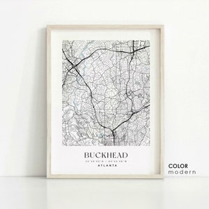 May include: A black and white map print of Buckhead, Atlanta, Georgia. The map shows the streets and roads of the area. The print is framed in a light wood frame. The text "BUCKHEAD" is printed at the bottom of the map, along with the coordinates "33°50'22"N / 84°22'48"W" and the word "ATLANTA". The text "COLOR modern" is printed in the bottom right corner of the image.