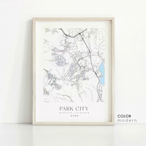 May include: A black and white line art map of Park City, Utah, with a light blue lake. The map is framed in a light wood frame. The text "PARK CITY" is printed below the map, along with the coordinates "40°39'01"N / 111°30'05"W" and the word "UTAH". The text "COLOR modern" is printed in the bottom right corner.