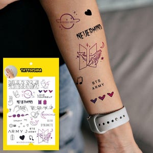 May include: A sheet of temporary tattoos featuring various designs inspired by the K-pop group BTS. The designs include the band's logo, song titles, and lyrics. The tattoos are printed in black and purple on a white background.