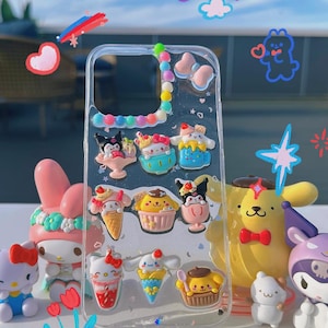 May include: A clear phone case with a colorful beaded border and various cartoon character charms. The charms are of ice cream cones, sundaes, and cupcakes. The case is decorated with glitter and small hearts.