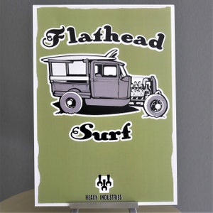 Puede incluir: Un póster verde y blanco con una ilustración vintage de una camioneta hot rod con una tabla de surf en la parte superior. El texto "Flathead Surf" está escrito en una fuente estilizada. El póster tiene un logotipo en la parte inferior que dice "Heavy Industries".