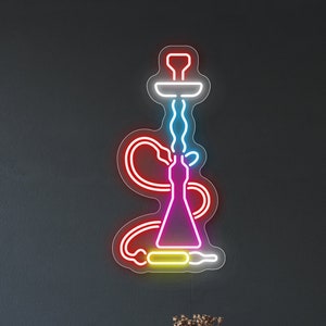 May include: A neon sign depicting a colorful hookah with a pink base, yellow hose, and blue smoke. The sign is mounted on a dark gray wall with a wooden table and a faux fur throw in the foreground.