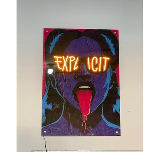 May include: A poster featuring a stylized illustration of a woman with a purple face, blue hair, and a red tongue. The word "EXPLICIT" is written in neon orange across the eyes.