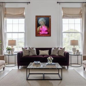 Puede incluir: Interior de sal&oacute;n con un sof&aacute; morado oscuro, dos sillones beige y una mesa de centro de m&aacute;rmol. Una obra de arte enmarcada con el texto "BE SAVAGE NOT AVERAGE" cuelga sobre el sof&aacute;. La habitaci&oacute;n tiene grandes ventanas y cortinas de tonos neutros.