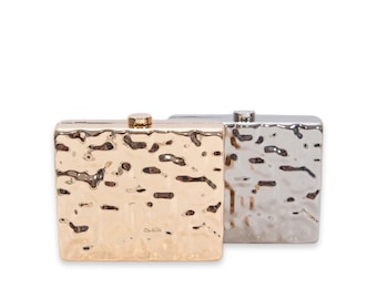 May include: Two square-shaped clutch purses with a hammered metal finish. One is gold and the other is silver.