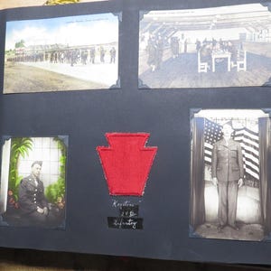 May include: A black scrapbook page featuring five vintage photographs and a central red keystone-shaped patch. The photos depict military scenes, including soldiers in formation, an indoor gathering, and a portrait of a soldier in front of a flag.