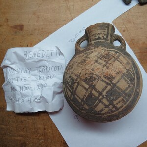May include: A terracotta bottle with a geometric pattern, labeled "Chancay Terracotta Bottle" Peru AD 1100-1200 4" x 4".