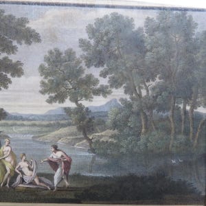 May include: An antique framed print depicting a classical landscape scene. The artwork features figures near a body of water, surrounded by trees and a distant mountain range. The frame has vertical stripes.