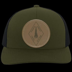 May include: A green and black trucker hat with a brown leather patch featuring a pine tree and the text "Pacific Crest Trail System".