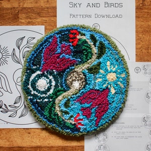 May include: A colourful, hand-stitched rug with a sky and bird theme. The rug is round and features a blue, green and red colour scheme. The text "SKY AND BIRDS PATTERN DOWNLOAD" is visible in the background.