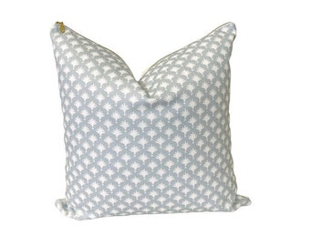 May include: A light blue throw pillow with a white geometric pattern. The pillow has a zipper closure.