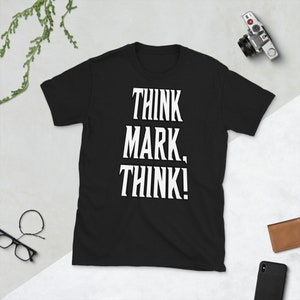 May include: Black short-sleeved t-shirt with white text that reads "Think Mark, Think!"