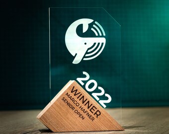 May include: A glass plaque with a white whale logo and the text "2022 Winner Marco Hafner Senior Open" on a wooden base.