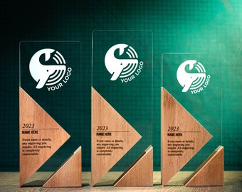May include: Three clear acrylic award plaques with wooden bases. Each plaque features a white whale logo with the text "YOUR LOGO" and the year "2023". The text "NAME HERE" is also included on each plaque, along with a description of the award's customization options.