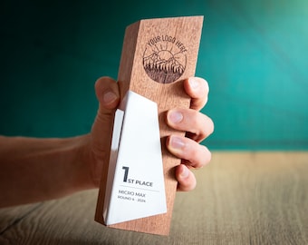 May include: A wooden award plaque featuring a mountain scene and the text "Your Logo Here". The plaque has a white insert with the text "1st Place", "Micro Max", and "Round 4, 2024".