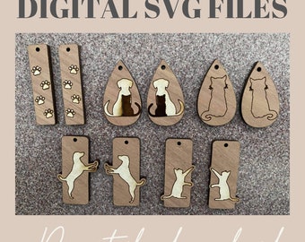 Könnte beinhalten: Digitale SVG-Dateien für Hunde- und Katzenohrring-Designs. Die Designs beinhalten Pfotenabdrücke, einen sitzenden Hund, einen stehenden Hund, eine sitzende Katze und eine stehende Katze.