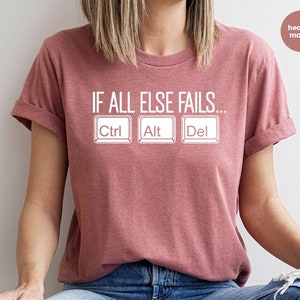May include: A heather mauve t-shirt with the text "IF ALL ELSE FAILS..." and three white computer keys labelled "Ctrl", "Alt", and "Del".
