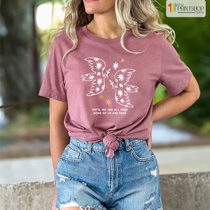 a woman wearing a pink shirt and denim shorts