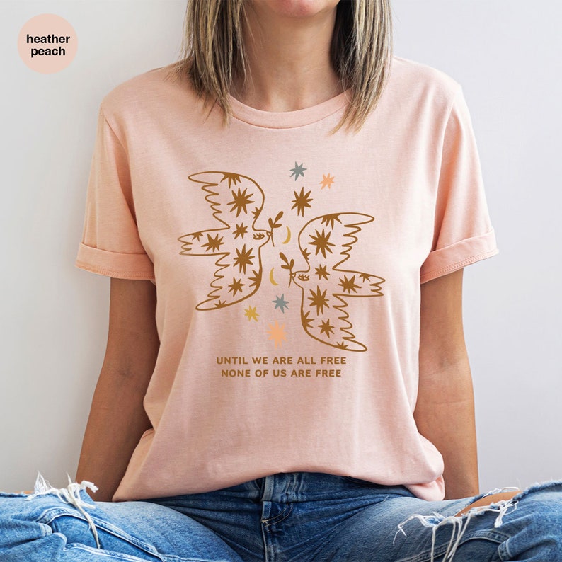 a woman wearing a pink t - shirt with a floral design