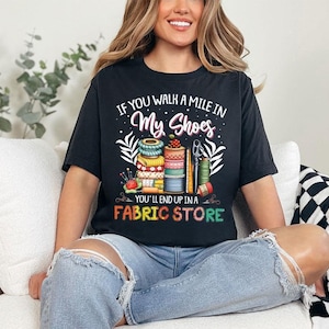 a woman sitting on a couch wearing a black shirt