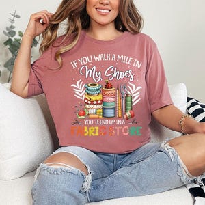 a woman sitting on a couch wearing a pink shirt