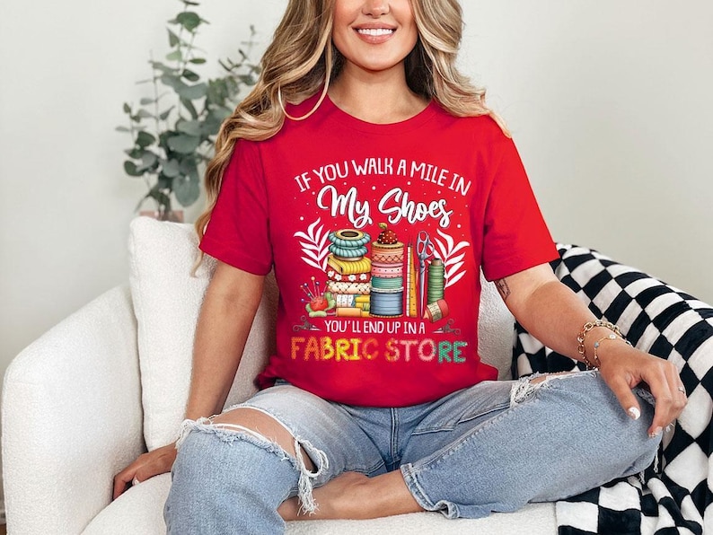 a woman sitting on a couch wearing a red shirt