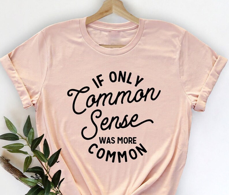Peut inclure: Un t-shirt rose p&acirc;le avec un texte noir qui dit "Si seulement le bon sens &eacute;tait plus courant".