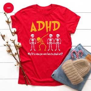 a red shirt with a skeleton and candy canes on it