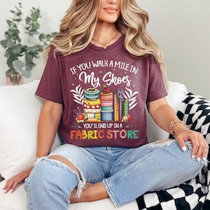 a woman sitting on a couch wearing a t - shirt