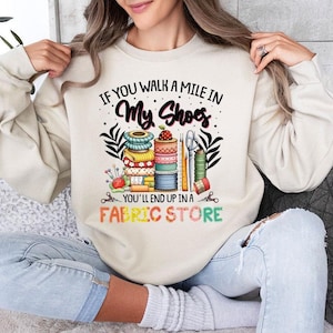 a woman sitting on a couch wearing a sweatshirt