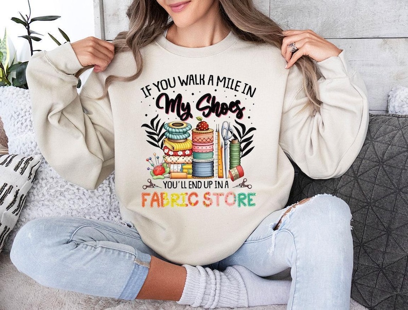 a woman sitting on a couch wearing a sweatshirt