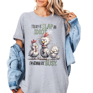 a woman wearing a gray tshirt that says today is slap an idiot i