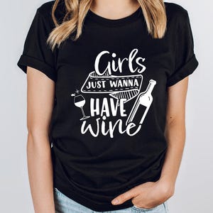 a woman wearing a t - shirt that says girls just wanna to have wine
