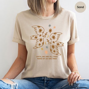 a woman wearing a t - shirt with an image of a bird on it
