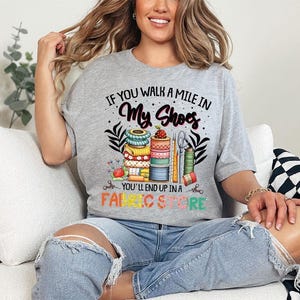 a woman sitting on a couch wearing a t - shirt