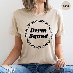 a woman wearing a t - shirt that says derm squad