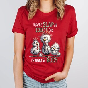 a woman wearing a red shirt that says today is slap an idiot day i '